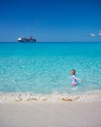 Rear view of woman swimming in sea against sky
