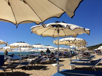 Umbrellas on beach against clear blue sky