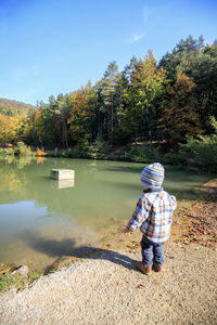 Full length of boy in lake against trees