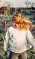 Rear view of woman standing on field