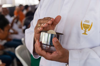 Middle part of priest holding host