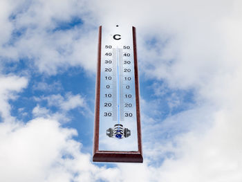 Low angle view of information sign against sky