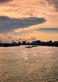 Scenic view of sea and buildings against sky during sunset