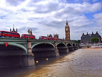 Bridge over river against cloudy sky