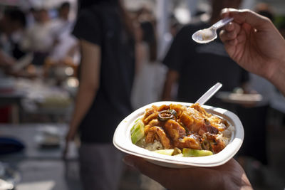 Cropped image of person holding ice cream in container