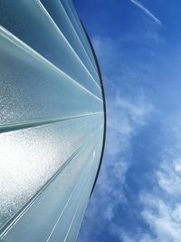 Low angle view of glass against blue sky