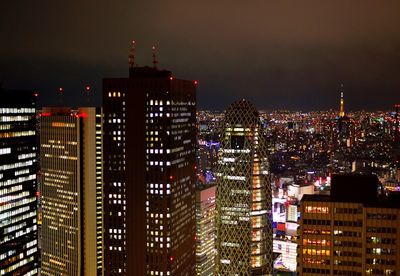 Illuminated cityscape against sky at night