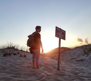 Man with text on beach against clear sky