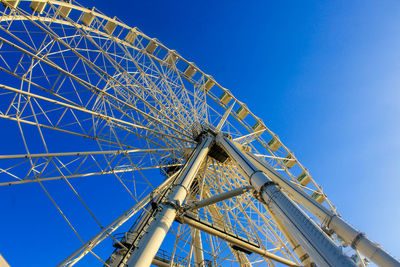 Low angle view of ferris wheel against blue sky