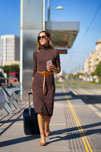 Portrait of young woman standing in city