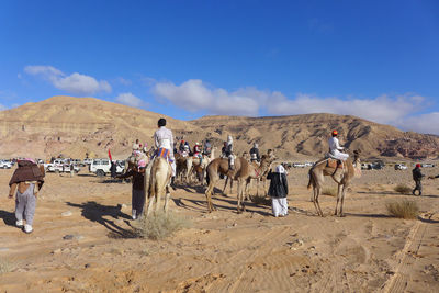 People on desert against sky