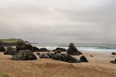 Rocks on beach against sky