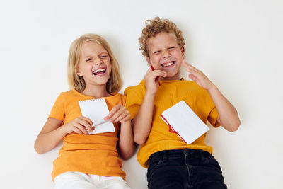 Smiling sibling lying on white background