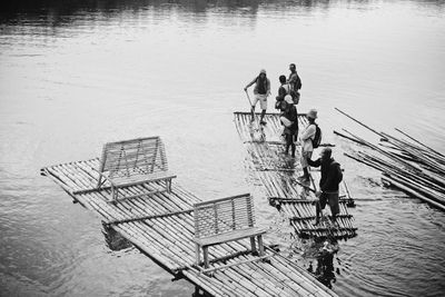 High angle view of men standing on wooden raft