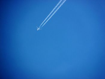 Low angle view of vapor trail against blue sky