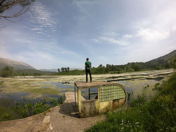 Man standing on mountain against sky