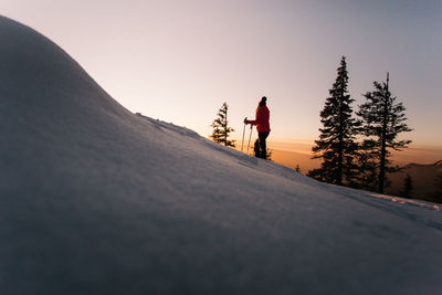 Man standing on snow covered mountain against sky