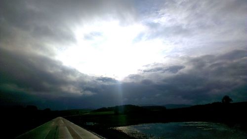 Empty road against cloudy sky