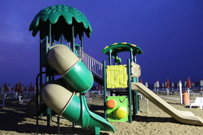 View of amusement park ride against blue sky