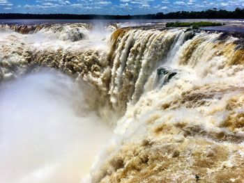 Scenic view of waterfall against sky