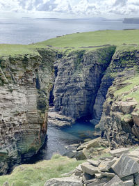 Rock formations by sea against sky