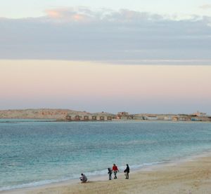 People at beach against sky