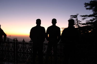 Rear view of silhouette people standing against sky during sunset