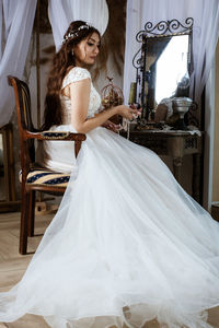 Bride sitting on chair at home