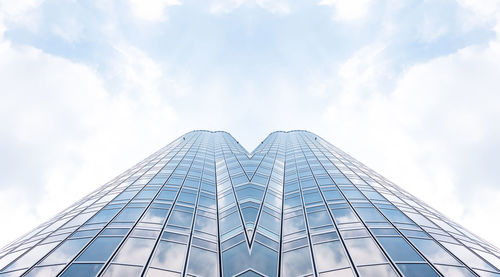 Low angle view of glass building against sky