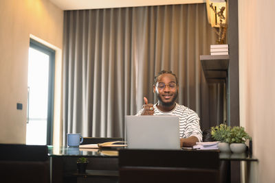 Side view of woman using laptop at home