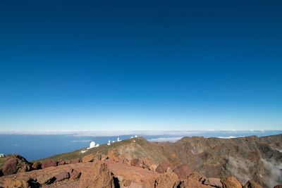 Scenic view of mountains against clear blue sky