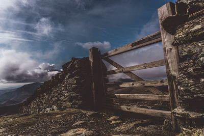 Abandoned built structure on landscape against sky