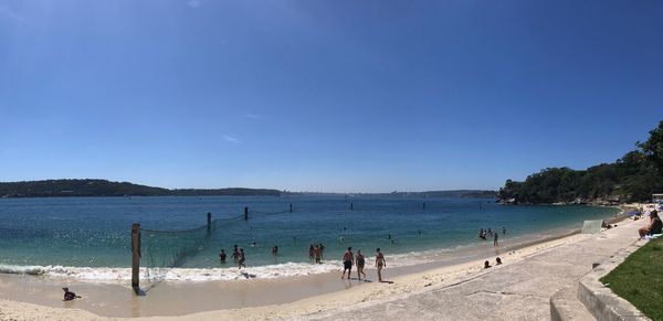 People at beach against blue sky