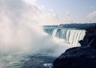 Scenic view of waterfall against sky