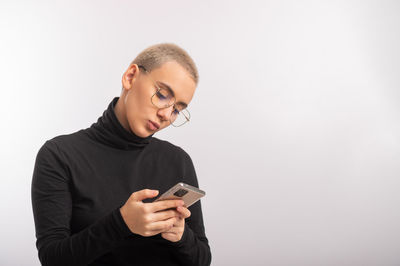 Mid adult man using smart phone against white background