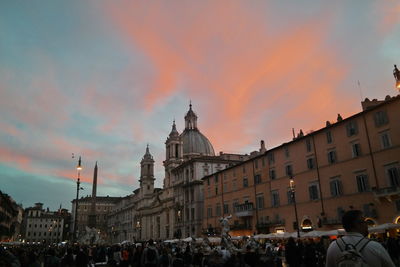 People walking in city at sunset