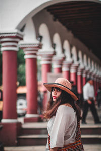 Full length of woman standing against wall