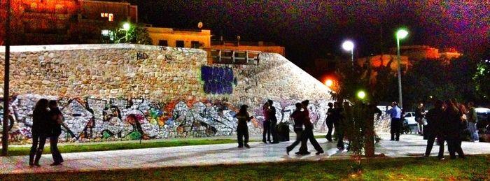 People in illuminated city at night