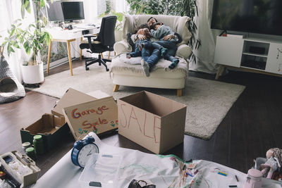 Mother with son and daughter resting in armchair at home