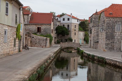 Canal amidst buildings against sky