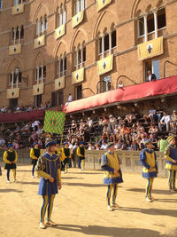 People walking on street against buildings in city