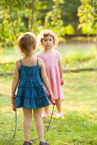 Siblings standing on grass at park
