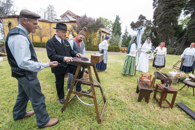 People standing on table against trees on field