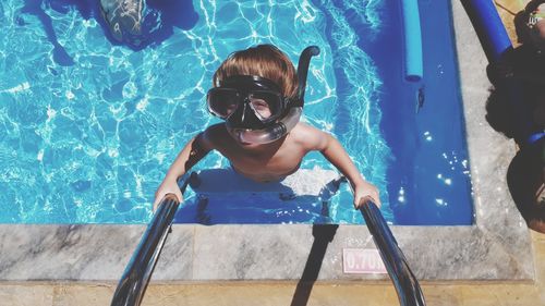 High angle view of boy in swimming pool during sunny day