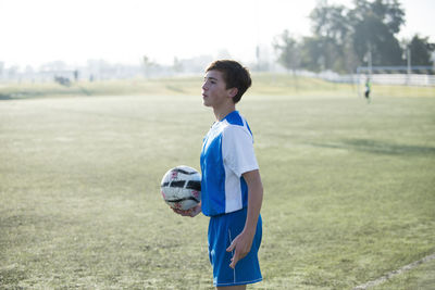 Teen soccer player holding ball and ready for a throw in