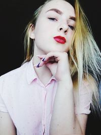 Portrait of woman with pink hair against black background