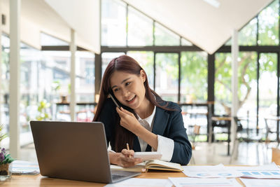 Businesswoman using laptop at office