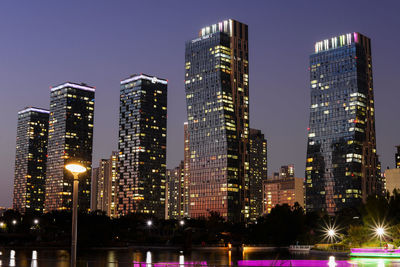 Illuminated buildings against sky at night