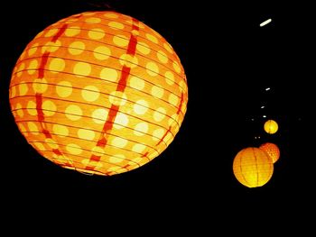 Low angle view of lanterns hanging against sky at night