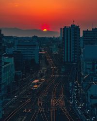 High angle view of illuminated cityscape at sunset